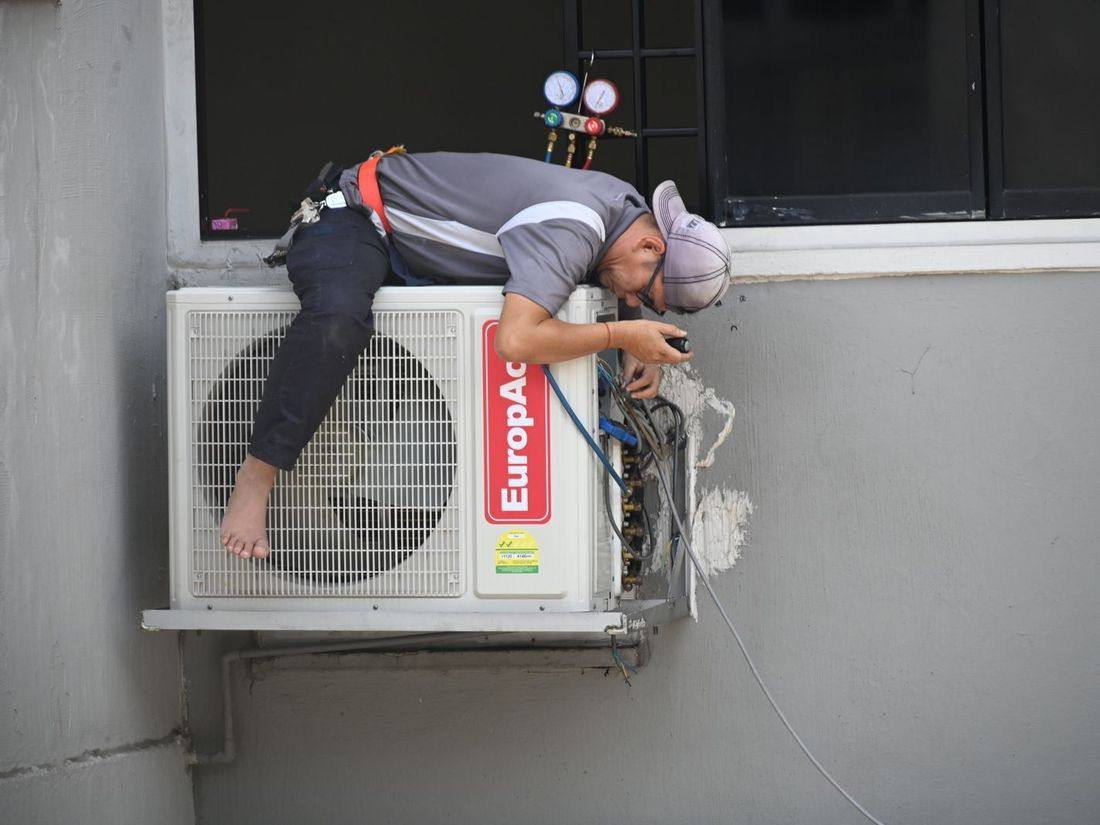 Technician repairing a wall-mounted air conditioning unit