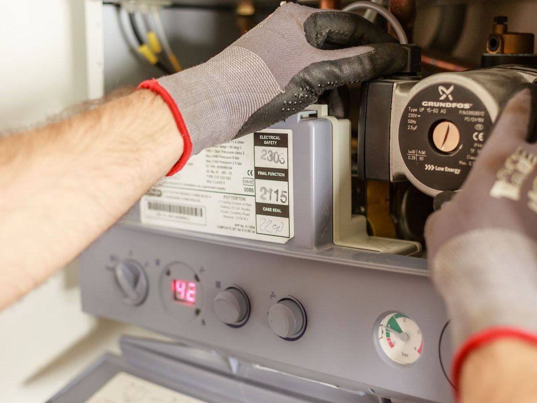 Technician servicing a wall-mounted water heater